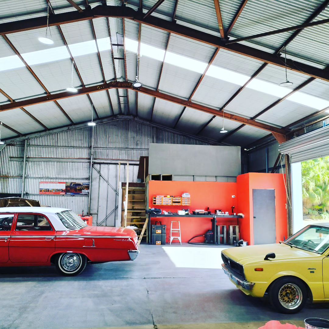 A red classic Chevrolet wagon and a vintage yellow coupe inside the Wireside workshop